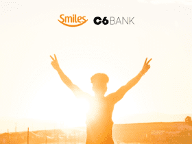 silhueta de uma pessoa com os braços abertos ao sol com logo Smiles e C6 Bank bônus Smiles
