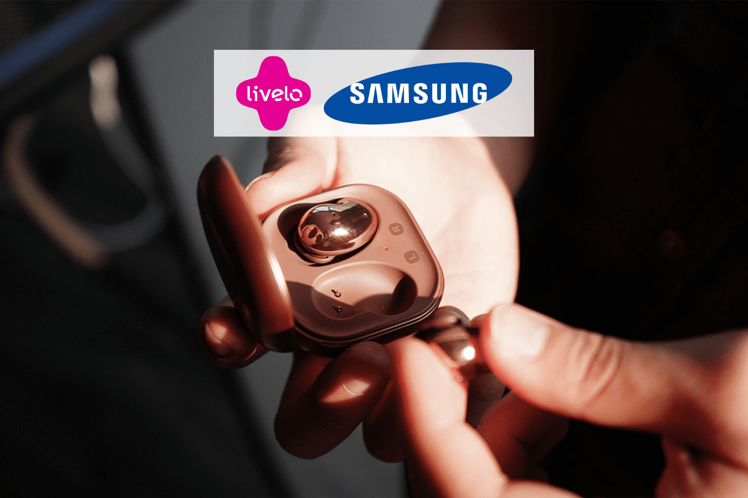 pessoa segurando um fone rosé com logo Liveo e Samsung 12 pontos Livelo