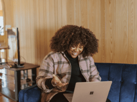 mulher preta olhando feliz para um notebook melhores promoções