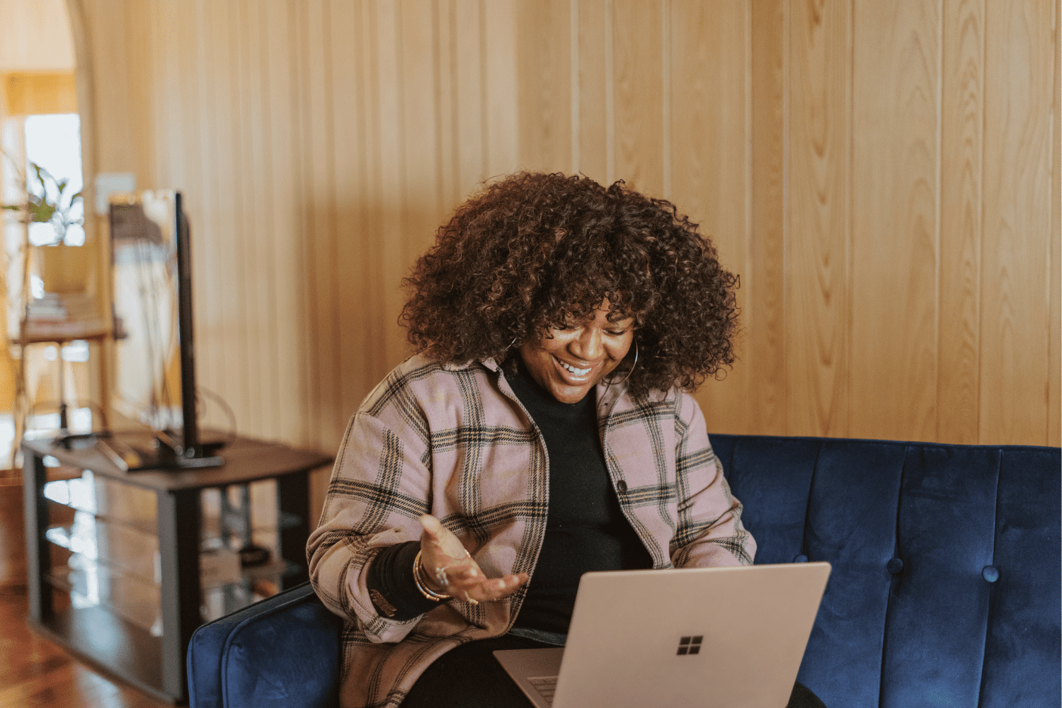 mulher preta olhando feliz para um notebook melhores promoções