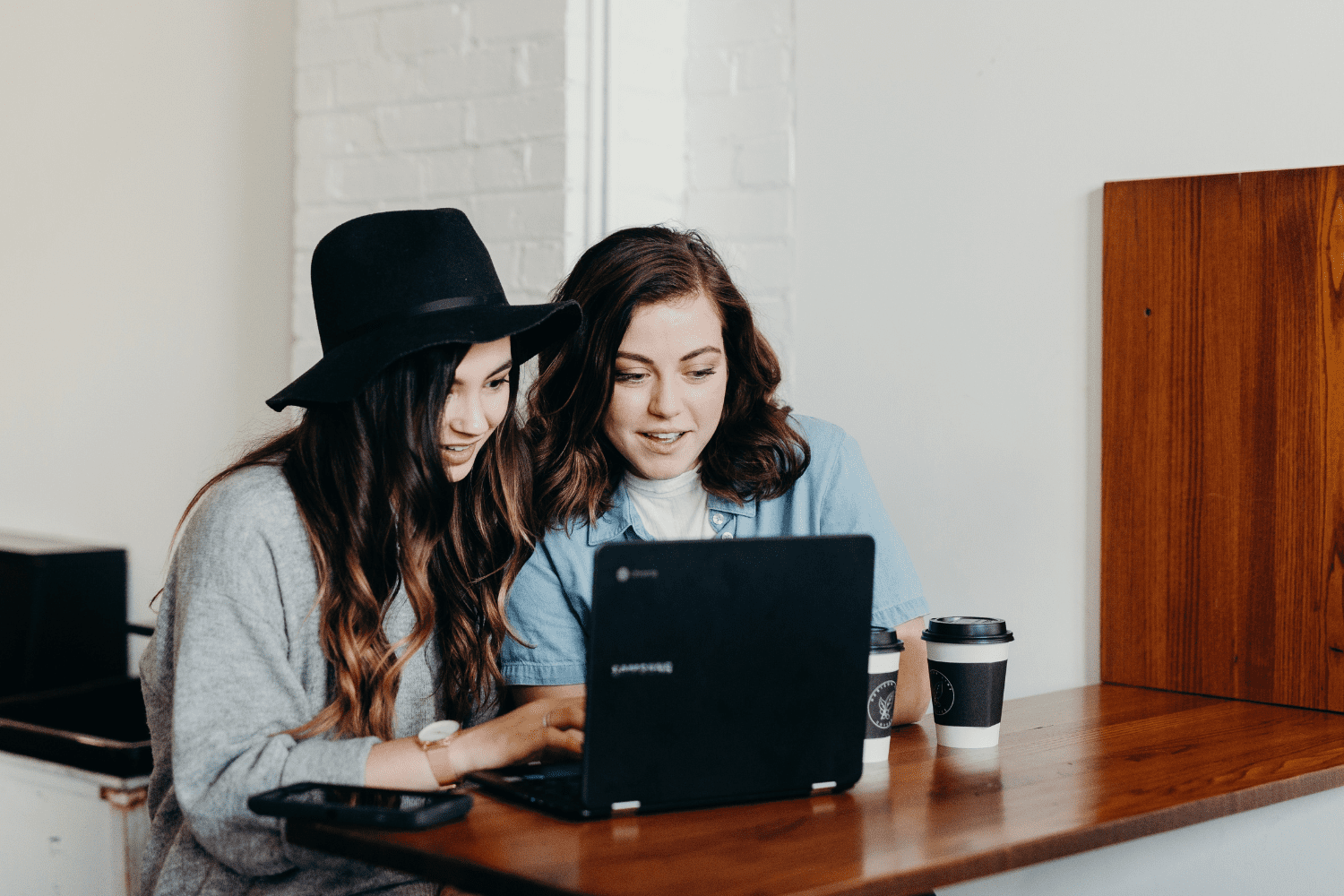 duas mulheres brancas olhando para um computador melhores promoções