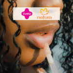 mulher negra passando creme labial com logo Livelo e Natura 15 pontos Livelo