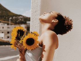 mulher preta tomando um sol com flores de girassol melhores promoções