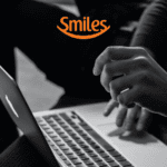 pessoa mexendo em um macbook com logo Smiles pontos Smiles