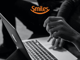 pessoa mexendo em um macbook com logo Smiles pontos Smiles