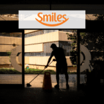 homem varrendo a frente de uma empresa com logo Smiles Pontos Smiles