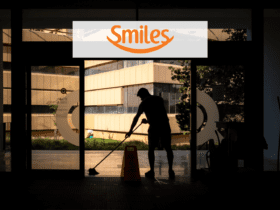 homem varrendo a frente de uma empresa com logo Smiles Pontos Smiles