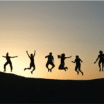 silhueta de um grupo de amigos pulando felizes melhores promoções