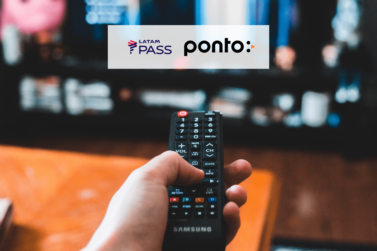 pessoa mexendo em um controle de televisão com logo Latam Pass e Ponto 12 pontos Latam Pass