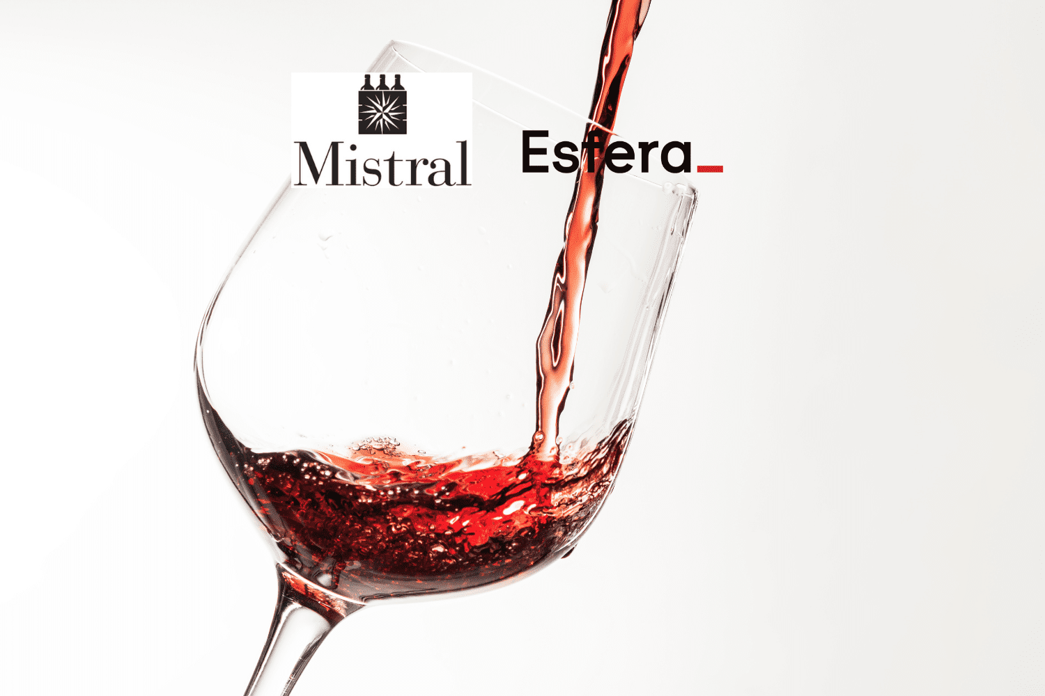 Vinho tinto sendo servido em uma taça transparente contra um fundo branco.