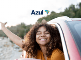 Mulher sorridente com a cabeça para fora da janela de um carro, aproveitando a viagem. Logo da Azul destacado na parte superior.
