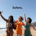 Pontos Esfera 50% OFF. Três mulheres sorrindo e tirando uma selfie em uma praia ensolarada, com o logotipo da Esfera no topo da imagem.