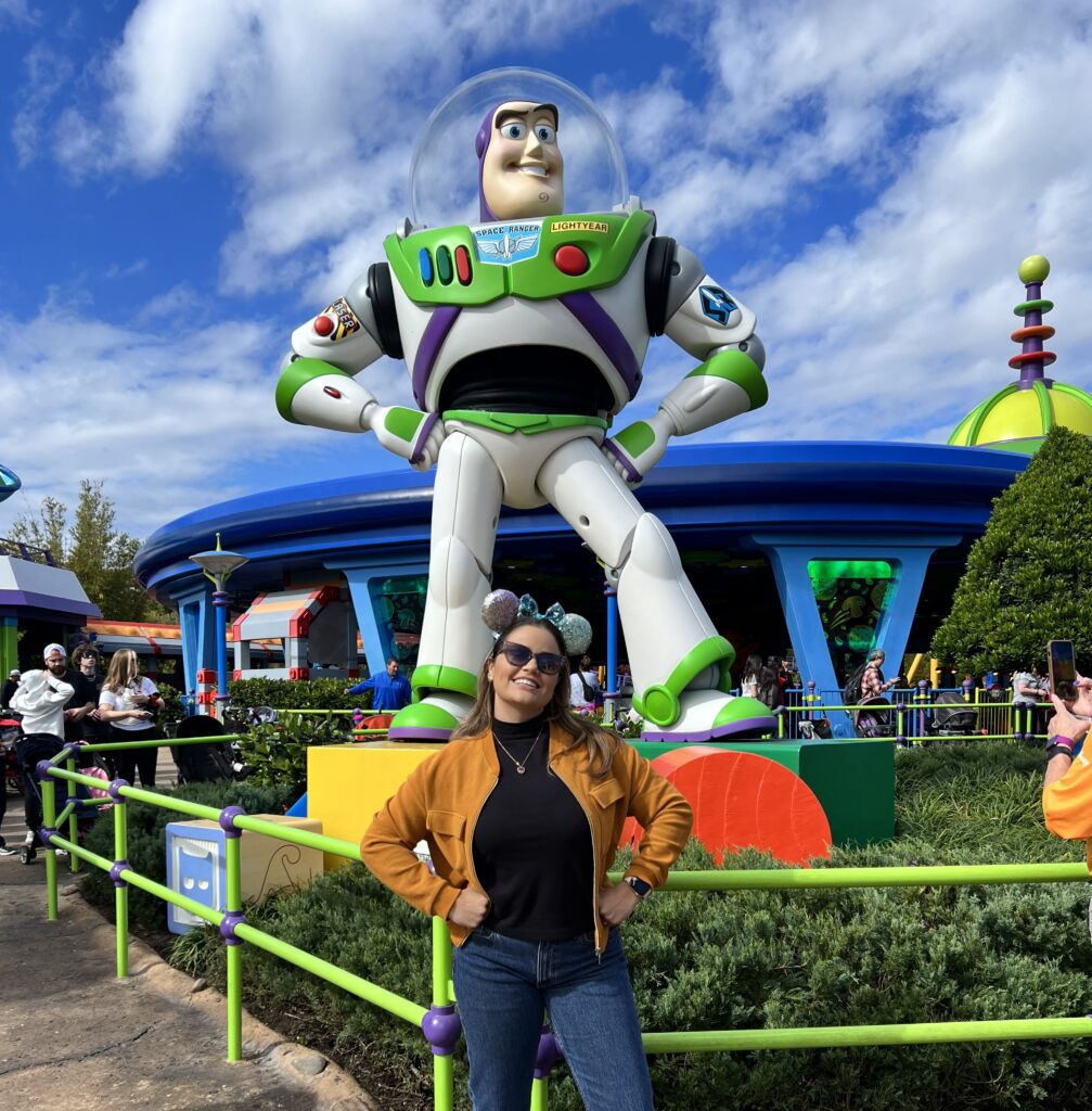 mulher loira fazendo a pose do buzz lightyear em parque da Disney  Viagem para a Disney
