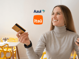 Imagem promocional destacando a parceria entre o Itaú e a Azul Linhas Aéreas. Ao centro, os logotipos do Itaú e da Azul estão posicionados juntos. À direita, uma mulher loira, sorridente, vestindo um suéter cinza claro, segura um cartão de crédito dourado em uma mão e um celular na outra, simbolizando a conveniência e os benefícios de usar os serviços do Itaú para aproveitar o programa de fidelidade da Azul. Ao fundo, um ambiente iluminado com cadeiras amarelas e uma mesa branca, acrescentando um toque moderno e acolhedor à cena. Ganhe até 100% bônus Azul com o Itaú.