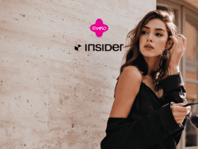 Mulher posando ao ar livre com um look sofisticado, acompanhada dos logos da Livelo e Insider. Ganhe 14 pontos Livelo com a Insider Store.