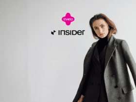 Imagem de uma mulher vestindo um casaco cinza, com os logotipos da Livelo e da Insider em destaque no centro. O fundo é branco e minimalista, destacando a elegância da roupa. Ganhe até 15 pontos Livelo com a Insider Store;