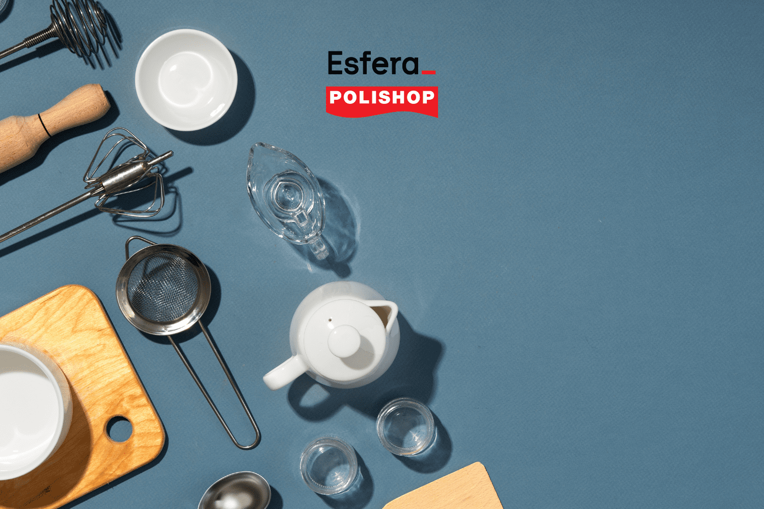 Imagem de utensílios de cozinha dispostos sobre uma superfície azul. Entre os itens visíveis estão um batedor manual, uma tábua de corte de madeira, um coador de metal, uma pequena jarra de vidro, uma batedeira manual, várias tigelas brancas, uma garrafa de vidro e uma chaleira branca. No canto superior direito, os logotipos da Esfera e da Polishop estão presentes, indicando uma parceria entre as duas marcas