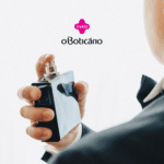 "Imagem de um homem visto de costas, vestindo um terno preto e gravata borboleta. Ele está segurando um frasco de perfume retangular com as mãos, prestes a aplicar o produto. No topo da imagem, há os logos da Livelo e do Boticário.