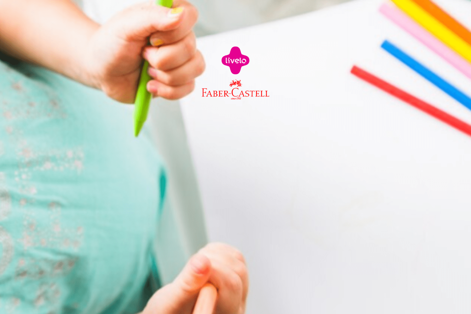 Mãos de uma criança segurando lápis de cor verde e laranja, enquanto desenha em um papel branco. No canto direito da imagem, há vários lápis de cor em diferentes cores (rosa, amarelo, azul, vermelho e laranja) alinhados sobre a mesa. A criança está vestindo uma camiseta verde clara com detalhes florais. No centro superior da imagem, estão os logotipos da Livelo e Faber-Castell, indicando uma parceria entre as duas marcas. A imagem transmite uma sensação de criatividade e diversão.