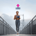 A imagem mostra uma mulher correndo em uma ponte com grades metálicas altas de ambos os lados. Ela veste um top azul e uma calça legging cinza, complementados por tênis brancos. O fundo da imagem exibe um céu parcialmente nublado. Acima da mulher, estão os logotipos da Livelo e da Olympikus, centralizados na parte superior da imagem.