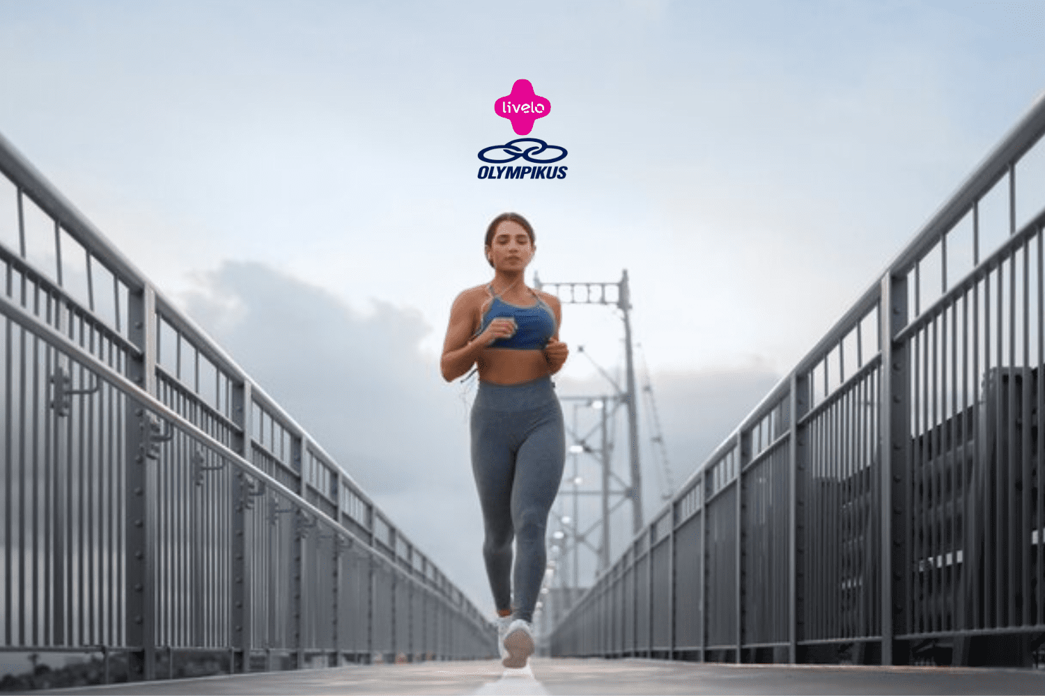A imagem mostra uma mulher correndo em uma ponte com grades metálicas altas de ambos os lados. Ela veste um top azul e uma calça legging cinza, complementados por tênis brancos. O fundo da imagem exibe um céu parcialmente nublado. Acima da mulher, estão os logotipos da Livelo e da Olympikus, centralizados na parte superior da imagem.