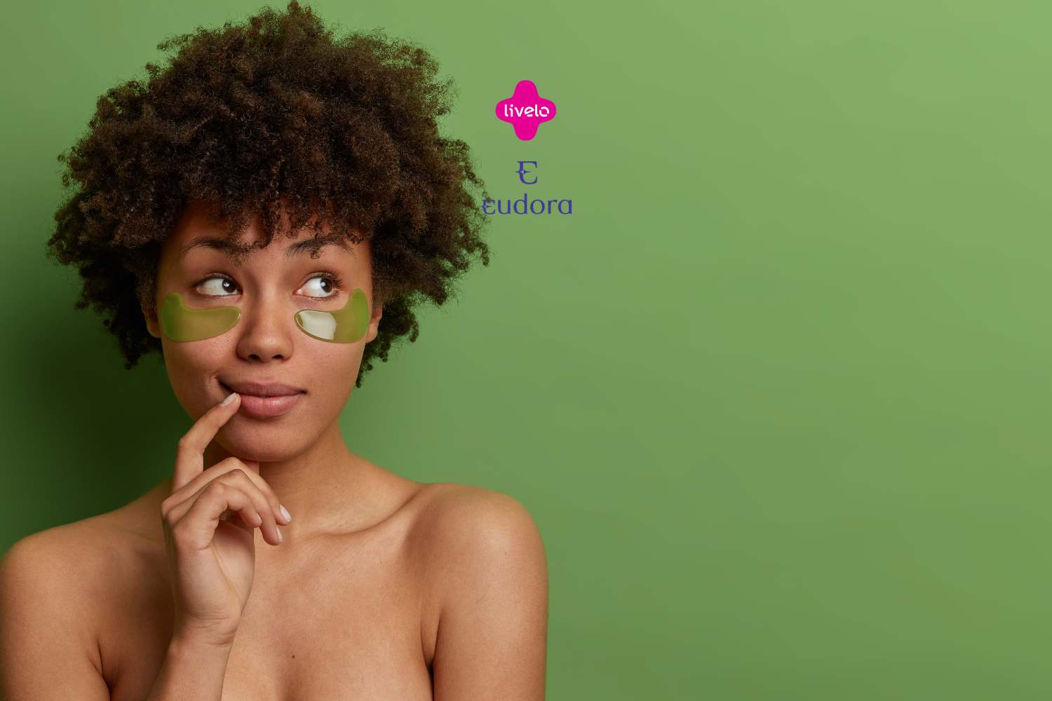 Uma mulher com cabelos cacheados e expressão pensativa está de pé contra um fundo verde. Ela tem dois adesivos verdes em forma de meia-lua sob os olhos, usados para cuidados com a pele. Acima dela, estão os logotipos da Livelo e da Eudora em rosa e roxo, respectivamente.