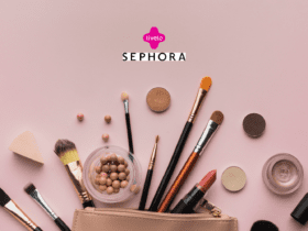 Conjunto de pincéis de maquiagem, batom, esponja e outros cosméticos dispostos sobre uma superfície rosa clara, ao lado de uma necessaire. Acima, estão os logos da Livelo e da Sephora, indicando uma colaboração de beleza e maquiagem.
