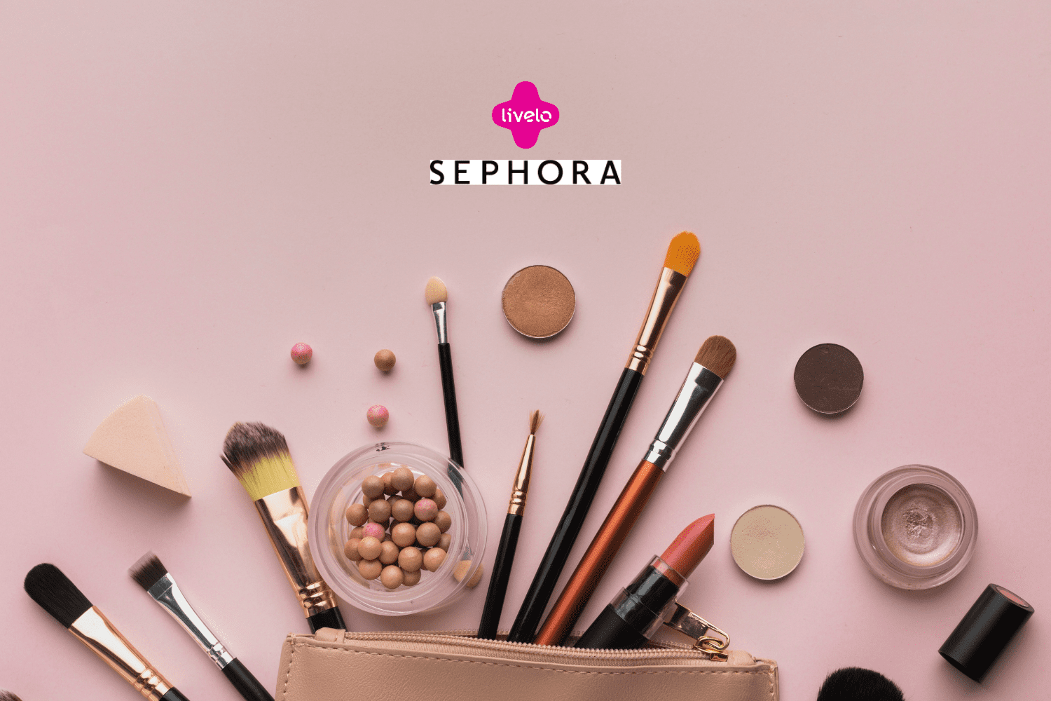Conjunto de pincéis de maquiagem, batom, esponja e outros cosméticos dispostos sobre uma superfície rosa clara, ao lado de uma necessaire. Acima, estão os logos da Livelo e da Sephora, indicando uma colaboração de beleza e maquiagem.