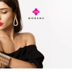 Mulher elegante com batom vermelho, usando brincos e pulseira dourados, vestida com um top preto de ombro a ombro. Ela olha para baixo, destacando os acessórios. Acima dela, estão os logos da Livelo e da Morana, sugerindo uma parceria de moda e joias.