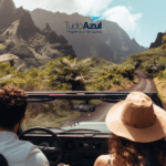 Casal dirigindo em um conversível por uma estrada cercada por vegetação exuberante e montanhas ao fundo. Acima deles, está o logo do programa de vantagens TudoAzul, sugerindo uma viagem cheia de aventuras e descobertas.