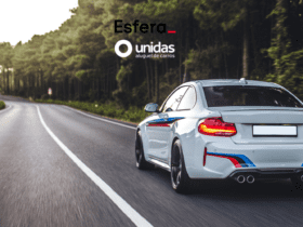 Carro esportivo branco dirigindo em alta velocidade por uma estrada cercada de árvores. Acima do carro, estão os logos da Esfera e da Unidas Aluguel de Carros, sugerindo uma viagem emocionante e confortável.