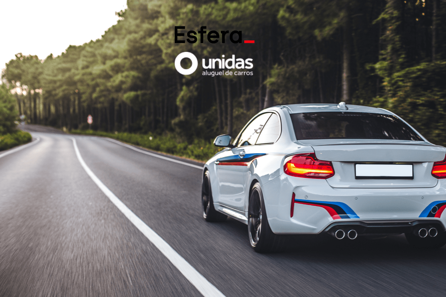 Carro esportivo branco dirigindo em alta velocidade por uma estrada cercada de árvores. Acima do carro, estão os logos da Esfera e da Unidas Aluguel de Carros, sugerindo uma viagem emocionante e confortável.