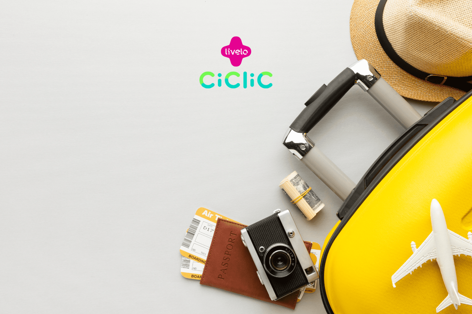 Uma mala amarela com um chapéu de palha e uma miniatura de avião estão ao lado de um passaporte, uma câmera vintage, passagens aéreas e uma pequena quantia de dinheiro em dólar enrolada. As logos da "Livelo" e "Ciclic" estão posicionadas acima da imagem.