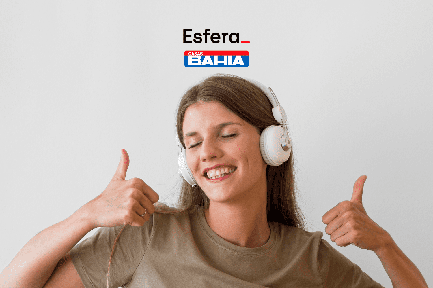 Imagem de uma mulher jovem sorrindo, usando fones de ouvido brancos e fazendo um sinal de "joinha" com as duas mãos. Acima da imagem, estão as logos da Esfera e das Casas Bahia.