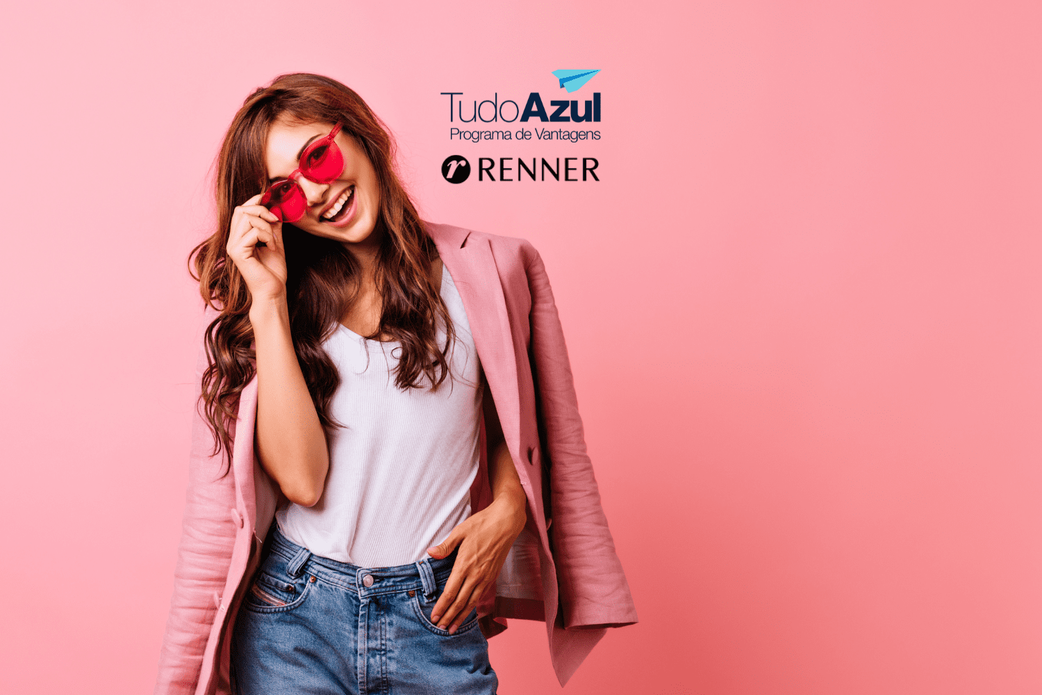 Imagem de uma jovem mulher sorridente, vestindo um blazer rosa e óculos de sol rosados, em um fundo também rosa. Acima da imagem, estão as logos do programa de vantagens TudoAzul e da loja Renner.