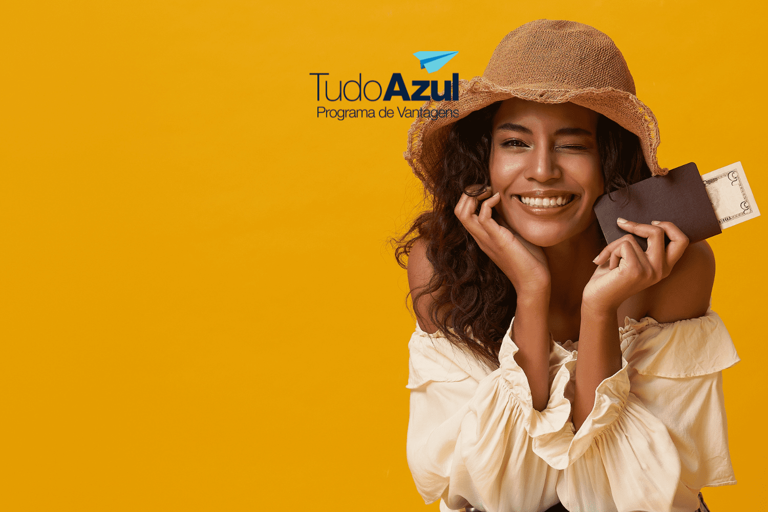 Mulher sorridente com chapéu segurando uma carteira com passagens aéreas, piscando para a câmera. Logotipo do TudoAzul está acima.