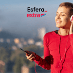 Mulher com cabelo curto ouvindo música com fones de ouvido, sorrindo e apreciando o momento ao ar livre. Logotipos da Esfera e Extra acima.
