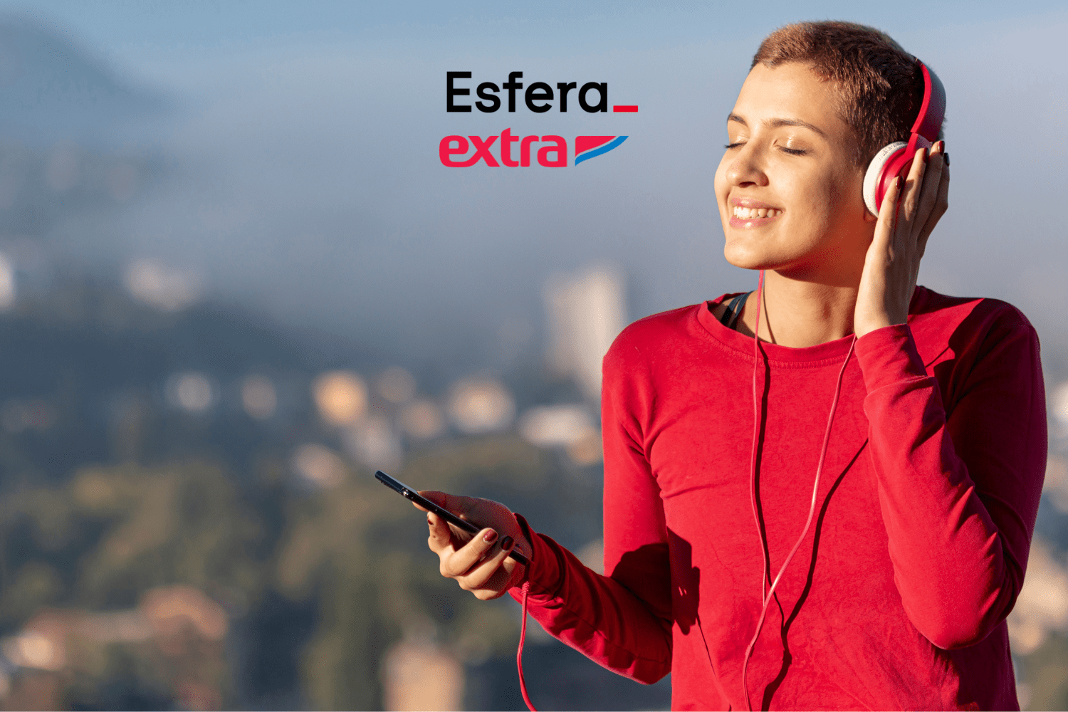 Mulher com cabelo curto ouvindo música com fones de ouvido, sorrindo e apreciando o momento ao ar livre. Logotipos da Esfera e Extra acima.