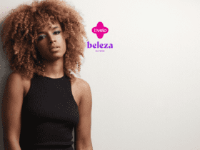 Descrição alternativa curta: Mulher com cabelo cacheado volumoso e maquiagem destacada, olhando para a câmera. Logotipo da Livelo e Beleza na Web acima.