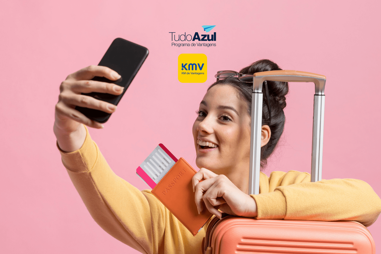 Imagem de uma jovem sorridente tirando uma selfie enquanto segura um passaporte e uma passagem aérea. Ela está ao lado de uma mala de viagem de cor laranja. Ao fundo, a parede rosa suave destaca a cena. No topo da imagem, estão as logos do programa de vantagens TudoAzul e do KM de Vantagens.