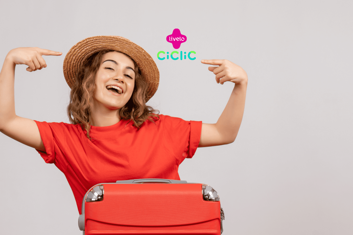 Mulher de cabelos castanhos sorridente com braços levantados e acompanhada de uma mala vermelha. Logo da Livelo e da Ciclic no canto superior da imagem