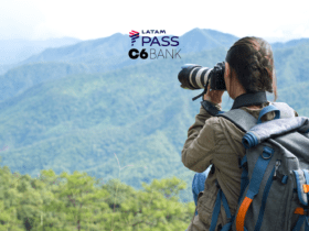 "Uma jovem fotógrafa, equipada com uma mochila e uma câmera profissional, fotografa a paisagem montanhosa à sua frente. O cenário é composto por montanhas verdes sob um céu claro, transmitindo tranquilidade e conexão com a natureza. Acima da imagem, estão os logotipos da LATAM Pass e C6 Bank, sugerindo uma parceria que oferece benefícios para viajantes e entusiastas da fotografia ao ar livre."