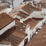 Vista aérea dos telhados de cerâmica e casas brancas típicas do centro histórico de Monsaraz; descubra a arquitetura local e onde fica Monsaraz.