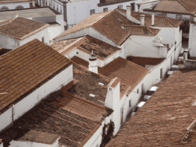 Vista aérea dos telhados de cerâmica e casas brancas típicas do centro histórico de Monsaraz; descubra a arquitetura local e onde fica Monsaraz.