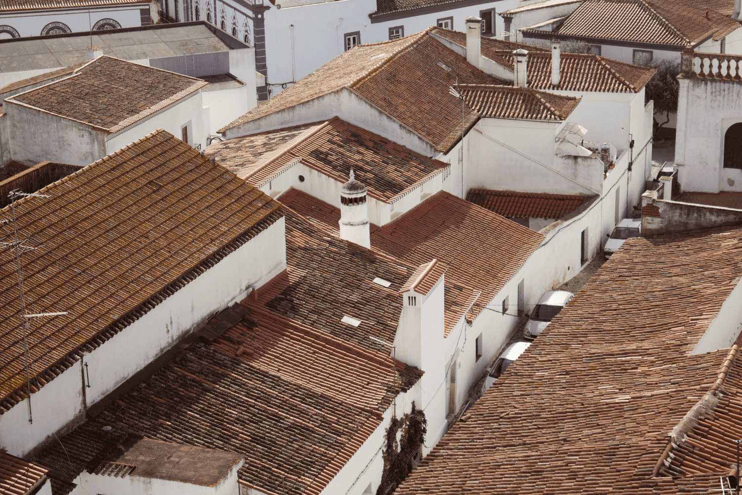 Vista aérea dos telhados de cerâmica e casas brancas típicas do centro histórico de Monsaraz; descubra a arquitetura local e onde fica Monsaraz.